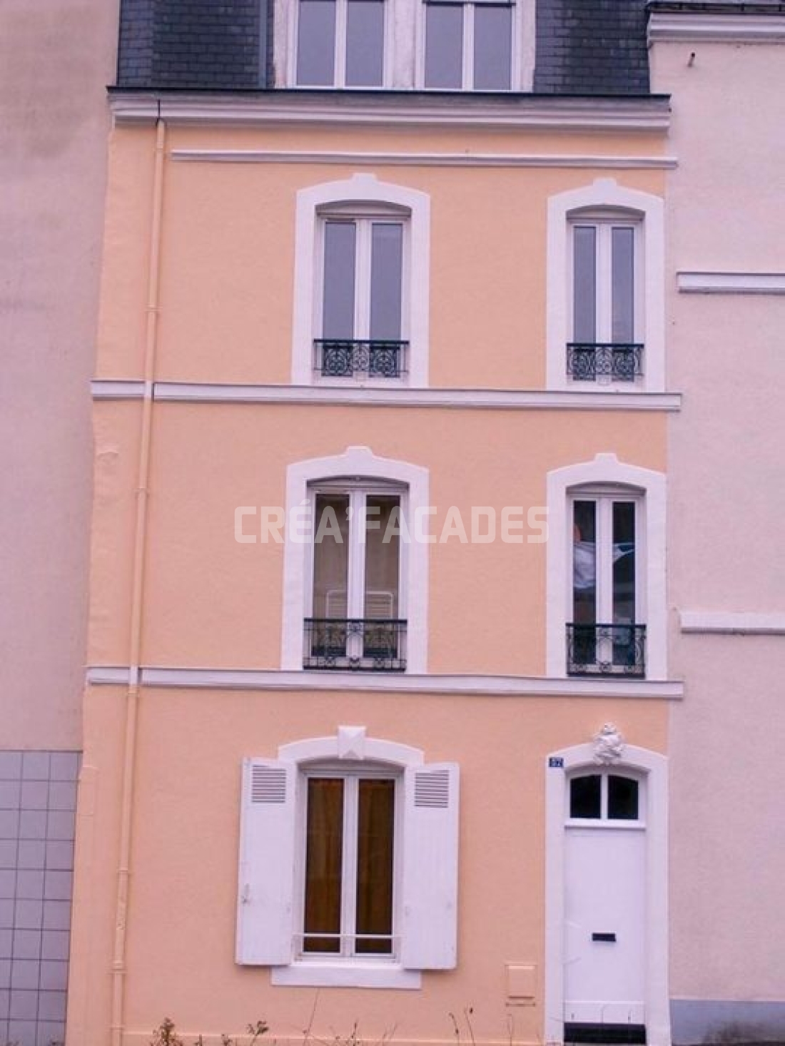 Façade d'une maison rénovée par Créa'Façades avec fenêtres blanches.